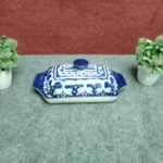 Large blue pottery butter dish with lid closed, seen from a high front angle