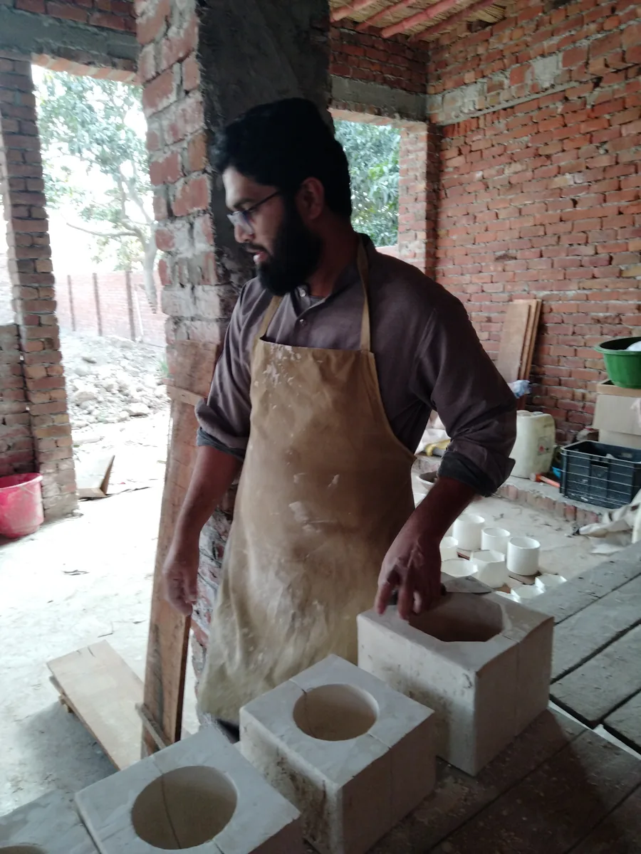 Checking an open square plaster mould with cylindrical cavities before casting