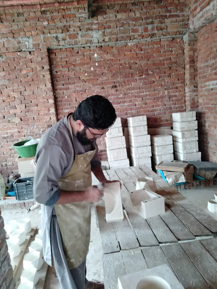 Nizam Ud Deen opening a plaster casting mould at the HMB Pottery workshop in 2022