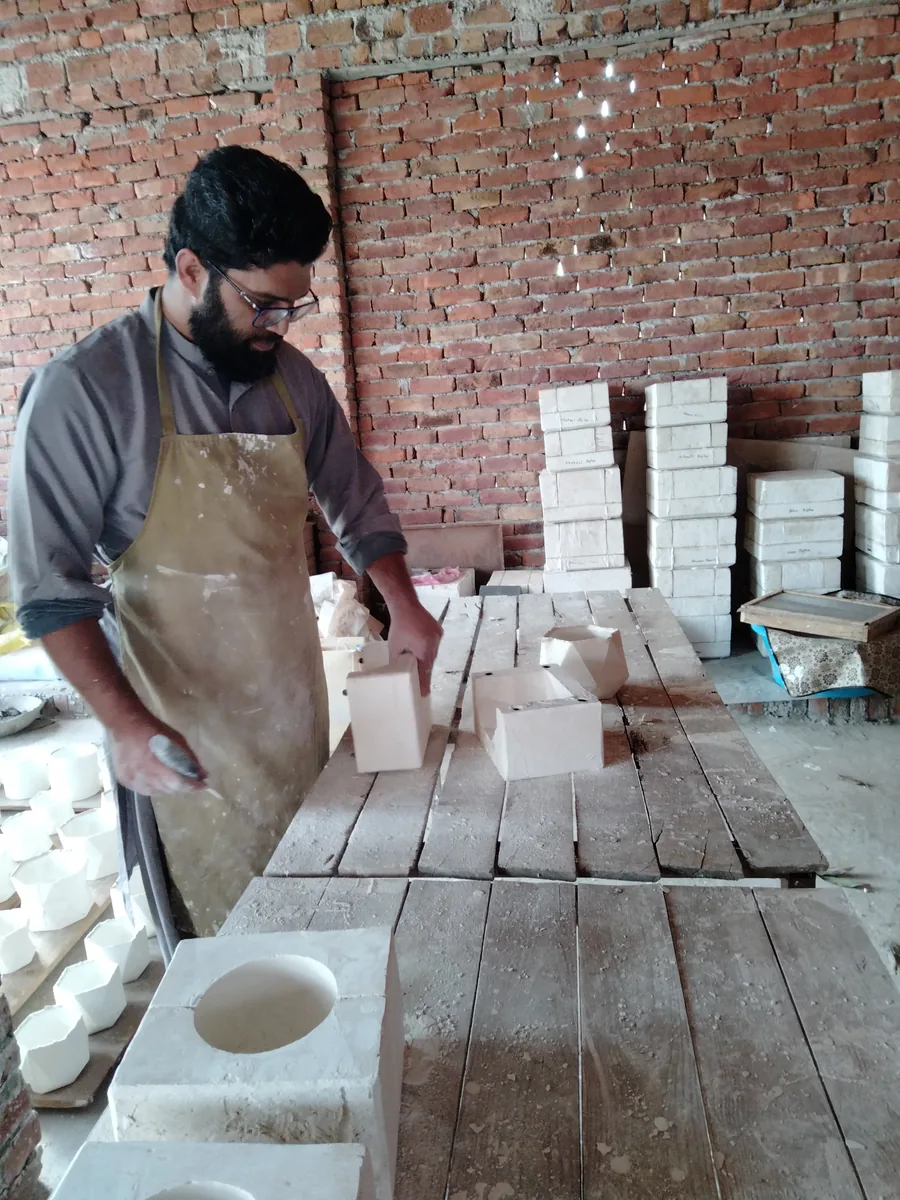 Stacks of plaster moulds behind the casting bench at the HMB Pottery factory