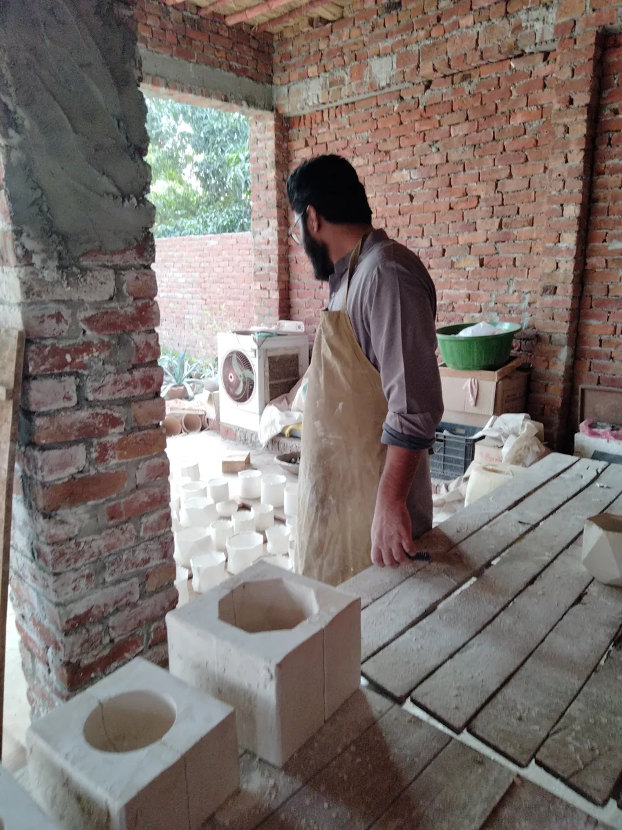 Working alone along the casting bench in the open brick workshop