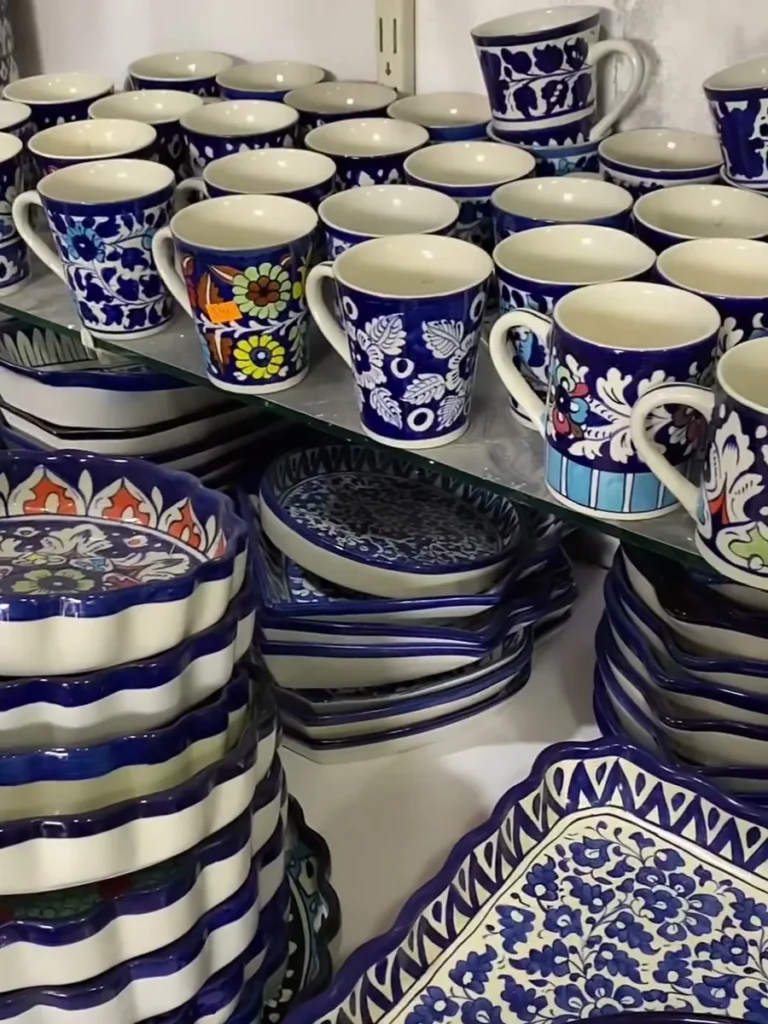 Hand painted mugs and stacked plates on the display table