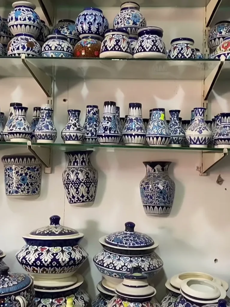 Hand painted vases and lidded jars on a showroom shelf