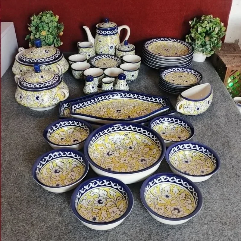 A dinner set for six in yellow and blue Multani pottery, with bowls, plates, a serving dish, a tea pot and a gravy boat