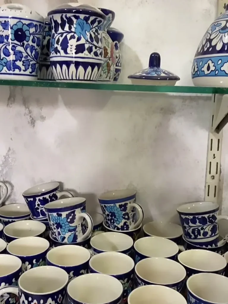 Hand painted mugs on a showroom shelf