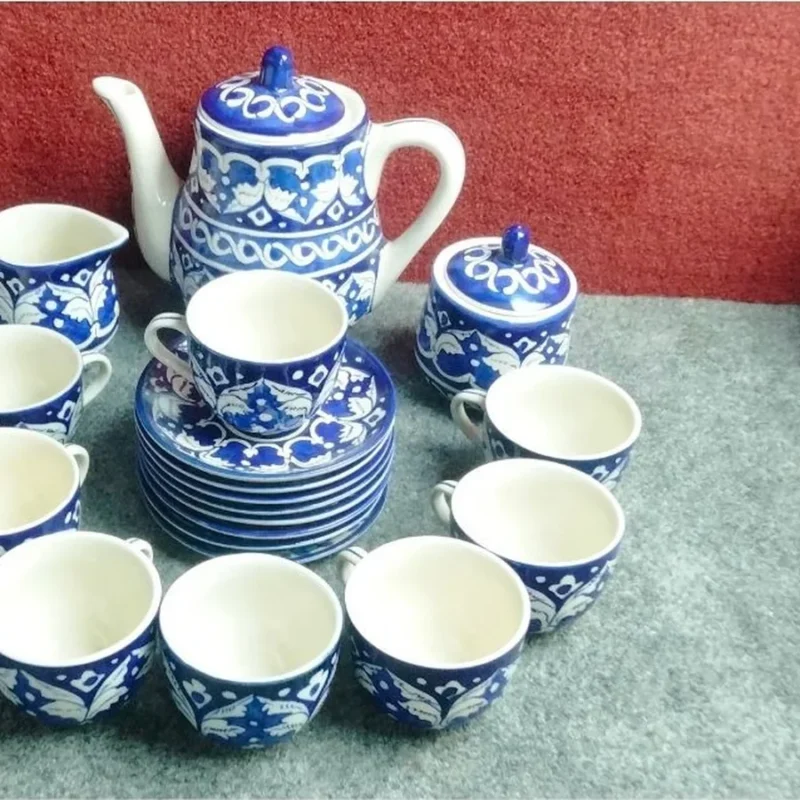 A hand painted tea set in blue and white Multani pottery, with a tea pot, sugar pot, milk jug, cups and saucers